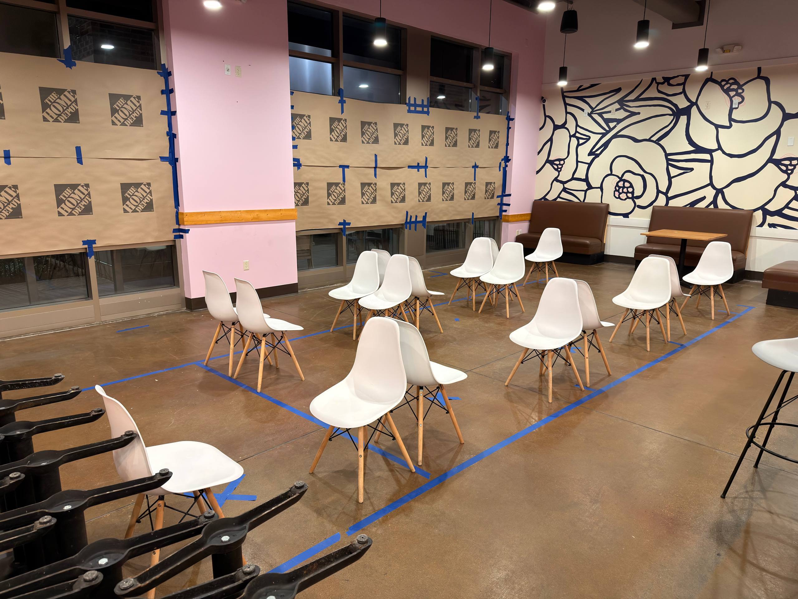 Dining room chairs arranged inside taped floor markings for seating layout testing